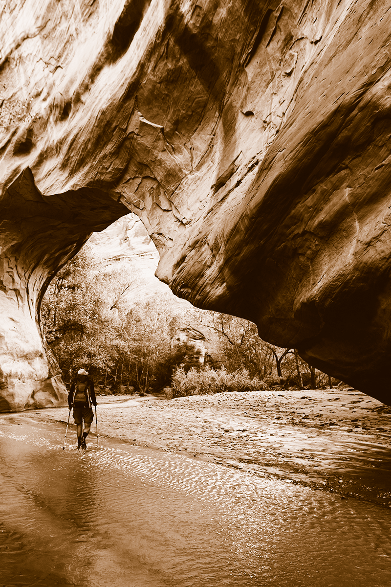 A hiker navigates through a rock canyon